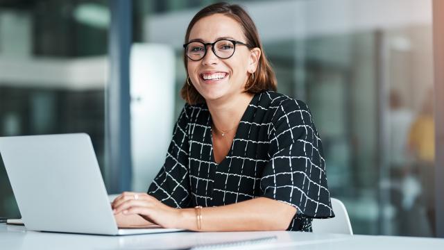 Person looking up from a laptop smiling