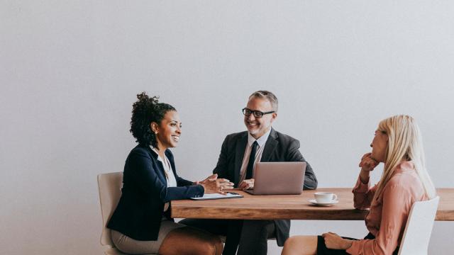 three people chatting at a table