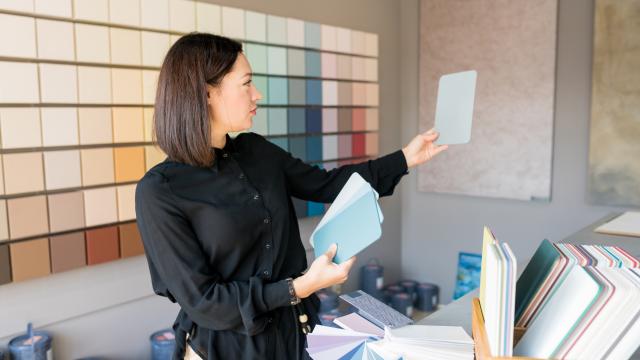 Interior designer standing in room deciding on color of walls.