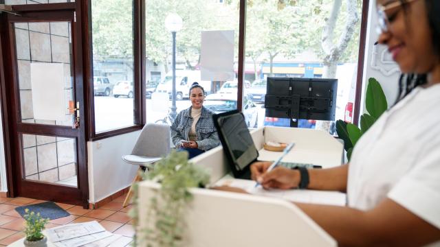 Medical Admin Assistant working at office with patient in waiting room