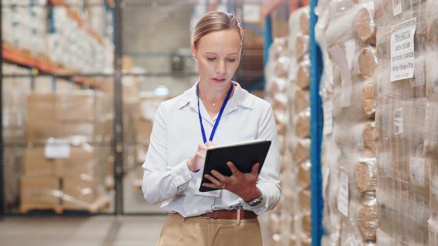 Individual in warehouse looking at tablet